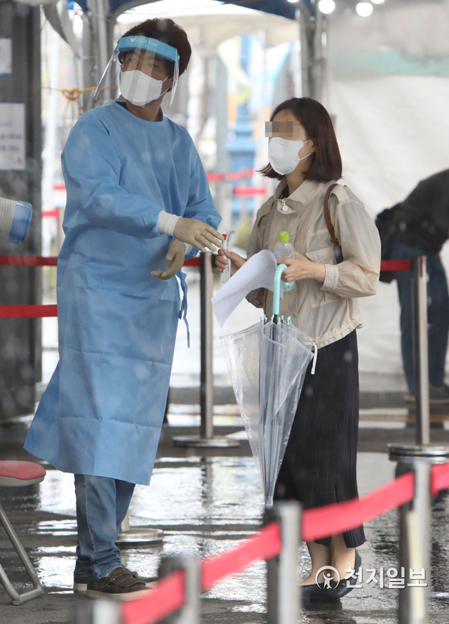 [천지일보=남승우 기자] 신종 코로나바이러스 감염증(코로나19) 신규 확진자가 1880명으로 집계된 21일 서울역 광장에 마련된 임시 선별검사소에서 한 시민이 우산을 들고 코로나19 검사를 받기 위해 대기하고 있다. ⓒ천지일보 2021.8.21