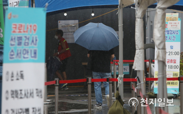 [천지일보=남승우 기자] 신종 코로나바이러스 감염증(코로나19) 신규 확진자가 1880명으로 집계된 21일 서울역 광장에 마련된 임시 선별검사소에서 한 시민이 우산을 쓴 채 코로나19 검사 접수를 하기 위해 이동하고 있다. ⓒ천지일보 2021.8.21