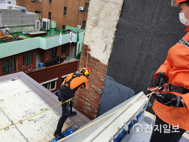 24일 오후 1시 15분경 부산 진구의 한 건물 외벽 타일이 떨어져 소방대원이 제거 작업을 하고 있다. (제공: 부산소방본부) ⓒ천지일보 2021.8.24
