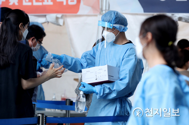 [천지일보=박준성 기자] 국내 신종 코로나바이러스 감염증(코로나19) 신규 확진자가 1882명으로 집계된 26일 오후 서울 도봉구 창동역에 설치된 임시선별검사소에서 의료진이 시민들에게 코로나 검사를 받기 전 일회용 비닐장갑을 전하고 있다. ⓒ천지일보 2021.8.26