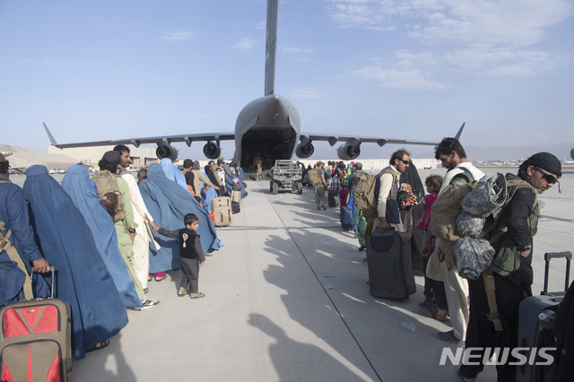 [카불=AP/뉴시스] 24일(현지시간) 아프가니스탄 카불의 하미드 카르자이 국제공항에서 아프간을 탈출하는 현지인들이 미 공군 C17 수송기에 탑승하고 있다.
