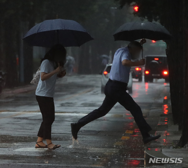 가을 장마로 인한 많은 비가 내리고 있는 31일 오후 서울 종로구 한 도로에서 시민들이 퇴근길 물웅덩이를 피해 발걸음을 재촉하고 있다. (출처: 뉴시스)