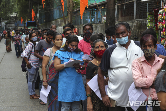 [뭄바이=AP/뉴시스] 17일(현지시간) 인도 뭄바이의 한 백신 접종소 앞에서 주민들이 백신 접종 순서를 기다리고 있다.
