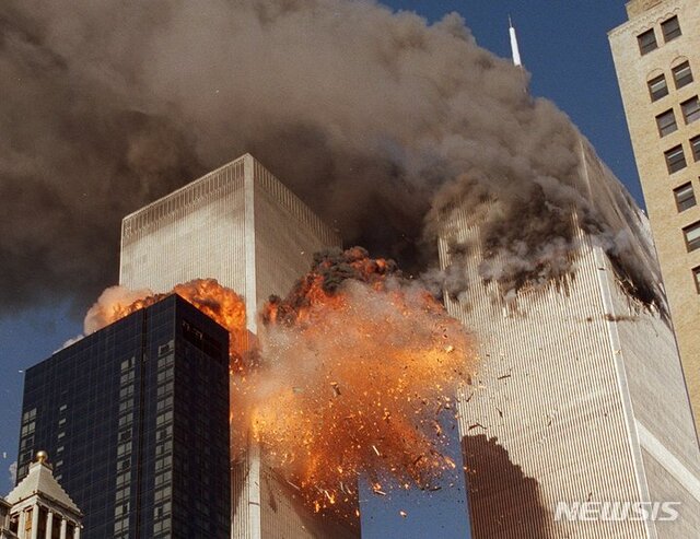 2001년 9월 11일 미국 뉴욕 세계무역센터에 테러 공격으로 납치된 비행기가 추락하면서 타워 중 하나에서 연기가 뿜어져 나오고 두 번째 타워에서 폭발이 발생하고 있다. (출처: 뉴시스)