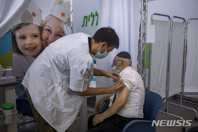 [텔아비브=AP/뉴시스] 10일(현지시간) 이스라엘 텔아비브에 있는 한 코로나19 백신 접종소에서 한 노인이 화이자 백신 3차(부스터 샷) 접종을 하고 있다.