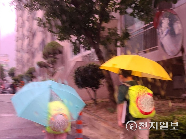 16일 경남 창원에 약간의 비가 내리는 가운데 초등학생이 우산을 쓰고 걸어가고 있다.ⓒ천지일보 2021.9.16