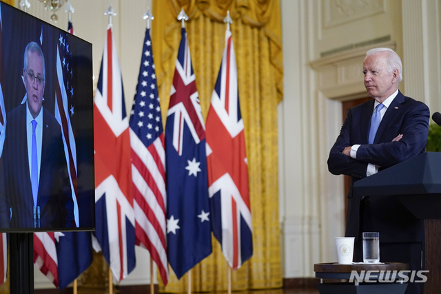 조 바이든 미국 대통령이 15일(현지시간) 백악관 이스트룸에서 스콧 모리슨 호주 총리, 보리스 존슨 영국 총리와 공동 화상 회의를 하며 모리슨 총리의 연설을 듣고 있다. (출처: 뉴시스)