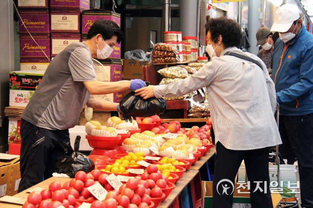 [천지일보 광주=이미애 기자] 추석 명절을 일주일 앞둔 지난 14일 광주 북구 말바우 전통시장 과일가게 주인이 손님이 산 ‘과일’을 봉지에 담아 양손을 받쳐 정성스럽게 건네고 있다. ⓒ천지일보 2021.9.17