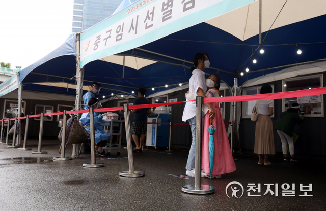 [천지일보=남승우 기자] 추석인 21일 오전 서울역 광장에 마련된 임시 선별검사소에서 한복을 입은 아이가 신종 코로나바이러스 감염증(코로나19) 검사를 받기 전 엄마 품에 안겨 있다. 방역당국에 따르면 이날 0시 기준 코로나19 신규 확진자는 1729명으로 집계됐다. ⓒ천지일보 2021.9.21