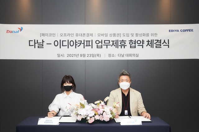 김주예 이디야커피 마케팅 본부장(왼쪽)과 박지만 다날 결제사업본부장이 23일 MOU를 체결하고 있다. (제공: 이디야커피)