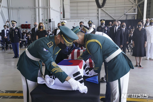 문재인 대통령과 김정숙 여사가 22일(현지시간) 미국 히캄 공군기지 19번 격납고에서 열린 한미 유해 상호 인수식에서 유해 관포 교체를 지켜보고 있다. (출처: 뉴시스)