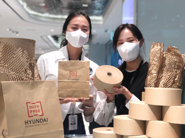직원들이 현대백화점면세점 인천공항점에서 종이 포장재를 소개하고 있다. (제공: 현대백화점면세점)