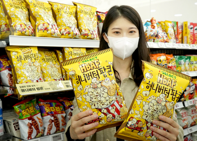 모델이 ‘세븐셀렉트 바프허니버터팝콘’을 선보이고 있다. (제공: 세븐일레븐)