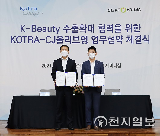 김상묵 KOTRA 혁신성장본부장(왼쪽)과 정윤규 CJ올리브영 경영지원담당 상무가 업무협약을 체결하고 기념촬영을 하고 있다. (제공: KOTRA) ⓒ천지일보 2021.9.29