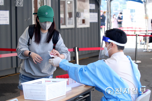 [천지일보=박준성 기자] 국내 신종 코로나바이러스 감염증(코로나19) 신규 확진자가 2086명으로 집계된 3일 오전 서울 서울광장에 설치된 임시선별검사소에서 의료진이 시민에게 코로나19 검체 채취키트를 전달하고 있다. ⓒ천지일보 2021.10.3