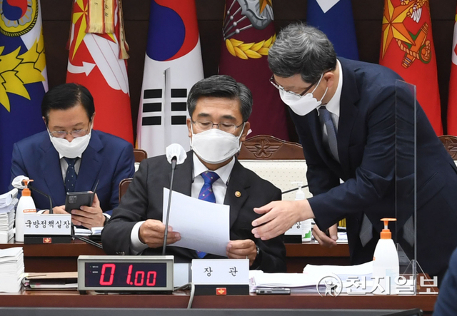[천지일보=박준성 기자] 서욱 국방부 장관이 5일 서울 용산구 국방부 본관 대회의실에서 열린 국회 국방위원회의 국방부에 대한 2021년도 국정감사에서 자료를 살펴보고 있다. 이날 국민의힘 의원들의 자리에 붙어 있는 ‘특검 거부하는 자가 범인이다’라는 피켓의 문제로 시작이 지연되고 있다. (사진공동취재단) ⓒ천지일보 2021.10.5