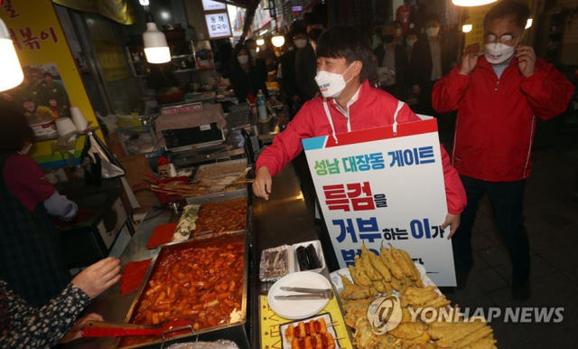(창원=연합뉴스) = '대장동 게이트 특검 촉구 도보 1인 시위'에 나선 국민의힘 이준석 대표가 16일 오후 경남 창원시 마산합포구 부림동 부림시장 내 떡볶이 매장 거리를 지나고 있다.해당 거리는 지난 6월 17일 경기 이천 쿠팡 물류센터 화재 사고 당시 이재명 경기지사와 맛 칼럼니스트 황교익 씨가 먹방을 했던 곳이다.