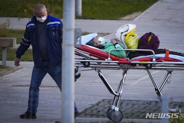 [모스크바=AP/뉴시스] 11일(현지시간) 러시아 모스크바 외곽의 코무나르카에 있는 한 병원에서 이곳 괸계자가 코로나19로 의심되는 환자를 들것에 실어 이동하고 있다.