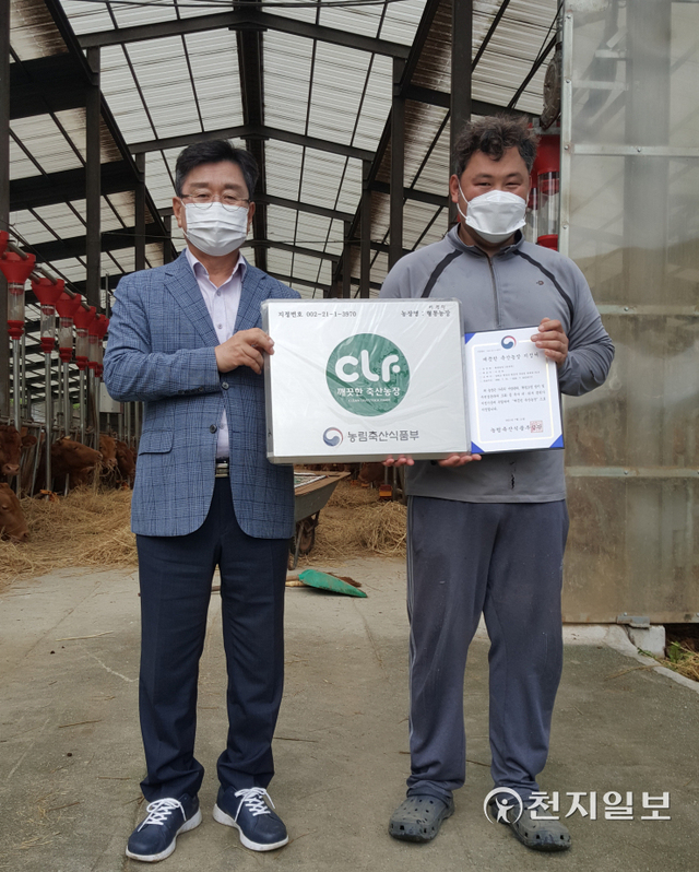 20일 장신상 횡성군수(좌측)가 횡성 우천면 하대리 깨끗한 축산농장으로 선정된 농장 대표에게 깨끗한 축산농장 지정서와 현판을 전달하고 기념촬영을 하고 있다. (제공: 횡성군청) ⓒ천지일보 2021.10.20