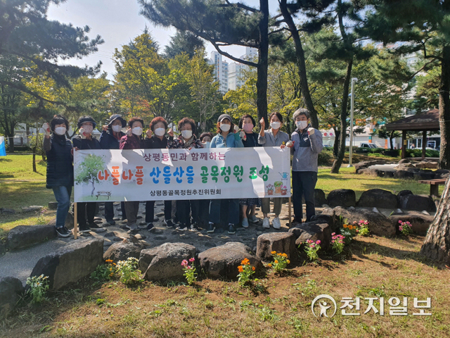 진주시 상평동 행정복지센터(동장 박경림, 오른쪽 두번째)가 지난 27일 골목정원추진위원회와 함께 꽃밭과 꽃길 조성을 마치고 기념촬영을 하고 있다. (제공: 진주시) ⓒ천지일보 2021.10.28