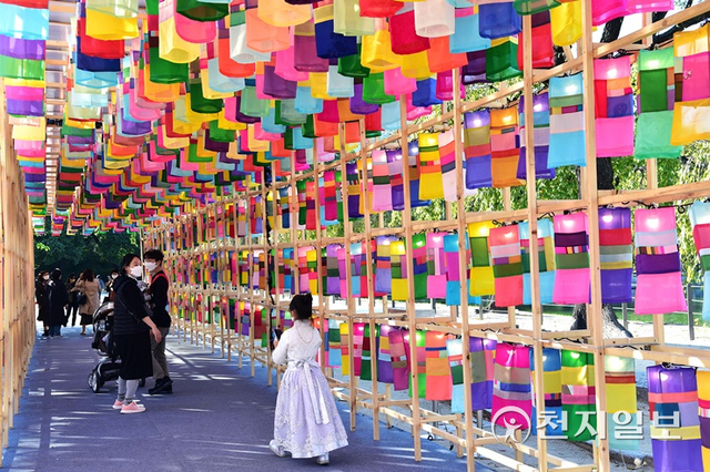 ‘2021년 제7회 궁중문화축전’에 2000여개의 등이 28m 길이로 늘어선 진주실크등 터널이 메인 전시물로 설치돼있는 가운데 참여객들이 구경을 하며 사진을 찍고 있다. (제공: 진주시청) ⓒ천지일보 2021.10.26