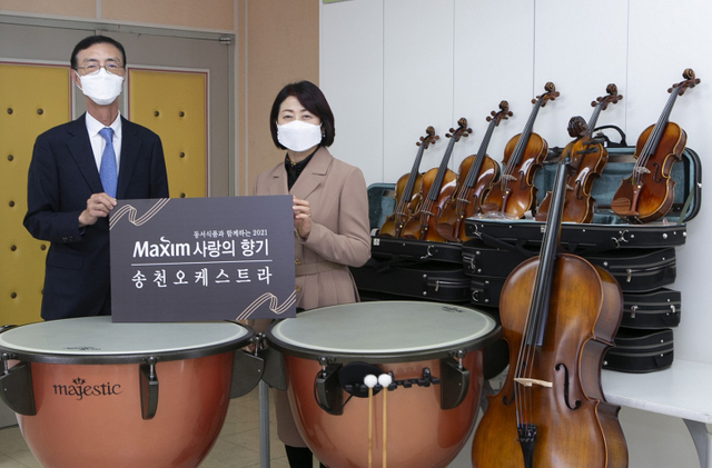 최상인 동서식품 홍보상무(왼쪽)와 이영숙 송천초등학교 교장(오른쪽)이 2일 인천광역시 남동구에 위치한 인천송천초등학교에서 진행된 ‘제14회 맥심 사랑의 향기’ 악기 기증식에서 기념촬영을 하고 있다. (제공: 동서식품)