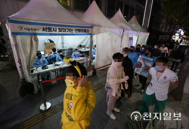 [천지일보=남승우 기자] 핼러윈데이를 하루 앞둔 30일 저녁 서울 용산구 이태원역 인근에 마련된 찾아가는 선별진료소 앞으로 각종 코스튬을 갖춰 입은 시민들이 지나가고 있다. ⓒ천지일보 2021.10.30