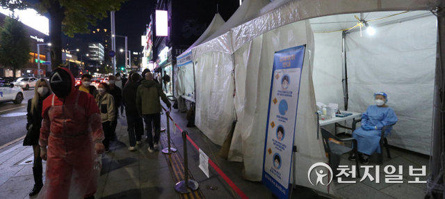 [천지일보=남승우 기자] 핼러윈 데이를 하루 앞둔 30일 저녁 서울 용산구 이태원역 인근에 마련된 찾아가는 선별진료소 앞으로 핼러윈을 즐기러 나온 시민들이 지나가고 있다. ⓒ천지일보 2021.10.30