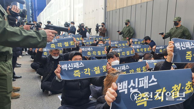 [천지일보=윤혜나 기자] 대한실내체육시설총연합회가 3일 서울 영등포구 더불어민주당 당사 앞에서 ‘실내 체육시설 백신 증명제 반대’라는 제목의 시위를 진행하고 있는 가운데 “백신 증명제를 선포한다”라고 외치며 군복을 입은 사람들이 모형 총으로 위협하는 퍼포먼스를 보이고 있다. ⓒ천지일보 2021.11.3