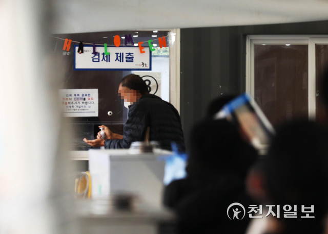 [천지일보=남승우 기자] ‘단계적 일상회복(위드 코로나)’ 시행을 하루 앞둔 31일 오전 서울역 광장 임시 선별검사소에 핼러윈 장식물이 걸린 가운데 검사를 마친 한 시민이 손소독을 하고 있다. 이날 신종 코로나바이러스 감염증(코로나19) 신규 확진자는 2061명으로 집계됐다. ⓒ천지일보 2021.10.31
