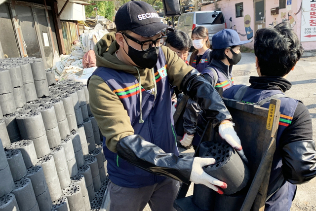 세븐일레븐 경영주들과 임직원들이 지난 3일 오전 서울 노원구 백사마을 방문해 연탄 나눔 봉사활동을 진행하고 있다. (제공: 세븐일레븐)