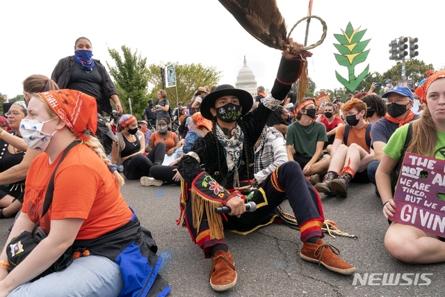 [워싱턴= AP/뉴시스] 올해 10월 15일 워싱턴의 미 의사당 앞에서 기후변화 대책을 요구하며 연좌시위 중인 나바호족 청년들과 아이라 프란티스코 (21. 가운데).  이들은 선조 때부터 지켜온 원주민의 땅과 환경에 대한 정책을 요구하며 