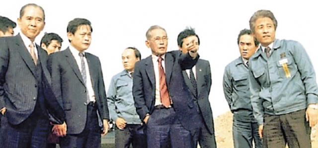 삼성 창업주인 이병철 선대회장(앞줄 오른쪽 두 번째)이 1983년 경기 기흥 반도체 공장터를 방문해 김광호 부회장(앞줄 맨 오른쪽)에게 지시하고 있다. 이건희 삼성 회장(앞줄 왼쪽 두 번째)도 보인다. (출처: 삼성전자)
