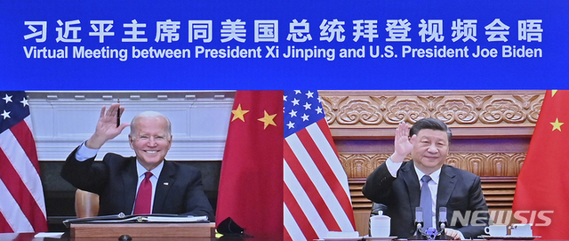 [서울=뉴시스] 중국 관영 신화통신이 공개한 사진으로, 16일 조 바이든(왼쪽) 미국 대통령과 시진핑(오른쪽) 국가주석이 첫 화상회담을 앞두고 손을 들어 인사하고 있다. 미중 정상간 첫 화상회담은 중국시간 16일 오전 8시46분(미국 동부 시간 오후 7시46분)께 시작됐다.