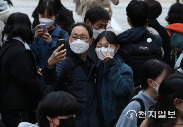 [천지일보=남승우 기자] 2022학년도 대학수학능력시험이 치러진 18일 오후 서울 종로구 덕성여자고등학교에 마련된 고사장에서 수능을 마친 수험생이 아빠와 함께 기념사진을 찍고 있다. ⓒ천지일보 2021.11.18