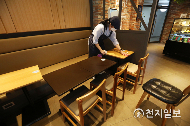 [천지일보=남승우 기자] 17일 오후 서울 시내의 한 프랜차이즈형 카페에서 아르바이트생이 테이블과 의자를 정리하고 있다. ⓒ천지일보 2021.1.17