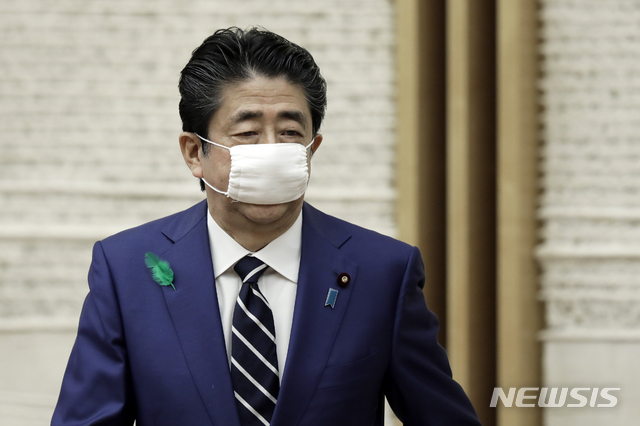 [도쿄=AP/뉴시스]지난해 4월17일 아베 신조 당시 일본 총리가 총리 관저에서 이른바 아베노마스크를 쓴 채 기자회견을 하기 위해 들어서고 있다. 2021.10.27.