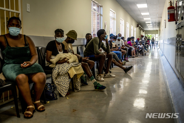 [요하네스버그=AP/뉴시스] 1일(현지시간) 남아프리카공화국 요하네스버그 인근 한 병원에 코로나19 백신을 접종하려는 시민들이 줄지어 앉아 있다. 오미크론 변이가 전 세계로 확산하는 가운데 남아공 의료진은 오미크론 변이 확진자들이 속단하긴 이르지만 지금까지 대부분 가벼운 증상만을 보인다고 보고했다.