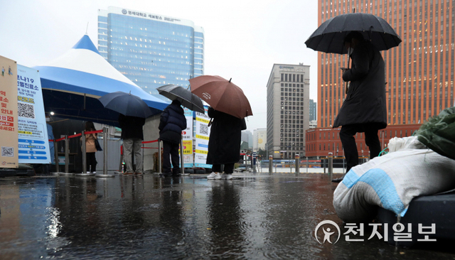 [천지일보=남승우 기자] 신종 코로나바이러스 감염증(코로나19) 신규 확진자가 3032명으로 집계, 위중증 환자는 어제보다 32명 늘어난 661명으로 역대 최다를 기록한 30일 오전 서울역 광장 임시 선별검사소에서 시민들이 우산을 쓴 채 코로나19 검사를 받기 위해 줄을 서서 기다리고 있다. ⓒ천지일보 2021.11.30