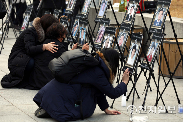 [천지일보=남승우 기자] 11일 오후 서울 서대문구 독립문공원에서 ‘코로나19 백신 피해자 가족협의회(코백회)’ 주최로 제 4차 촛불집회가 열린 가운데 유가족들이 영정 사진을 어루만지고 있다. ⓒ천지일보 2021.12.11