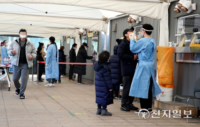 [천지일보=박준성 기자] 국내 신종 코로나바이러스 감염증(코로나19) 신규 확진자가 6689명으로 집계된 12일 서울 중구 서울시청 광장에 설치된 임시선별검사소에서 의료진이 코로나19 검사를 받는 시민의 검체를 채취하고 있다. 위중증 환자 수는 894명으로 전날(856명)보다 38명 늘어나면서 지난 8일부터 닷새 연속 800명대를 기록했다. ⓒ천지일보 2021.12.12