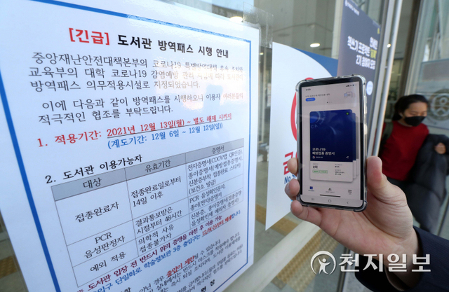 [천지일보=남승우 기자] 식당·카페 등 다중이용시설 16곳에 적용 중인 방역패스(접종증명·음성확인제) 시행이 의무화된 13일 오후 서울 서대문구 연세대학교 중앙도서관 입구에 관련 안내문이 붙어 있다. ⓒ천지일보 2021.12.13