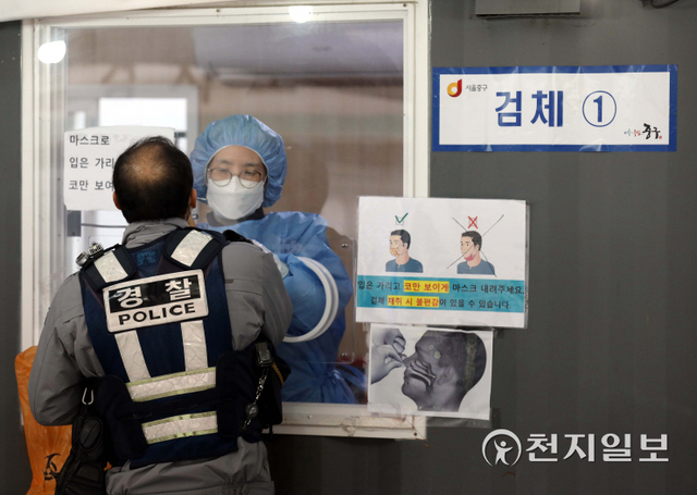 [천지일보=남승우 기자] 신종 코로나바이러스 감염증(코로나19) 신규 확진자가 5567명으로 집계된 14일 오전 서울역 광장 임시 선별검사소에서 경찰이 코로나19 검사를 받고 있다. 이날 위중증 환자 수는 906명, 사망자 수는 94명으로 역대 최다 수치를 기록했다. ⓒ천지일보 2021.12.14