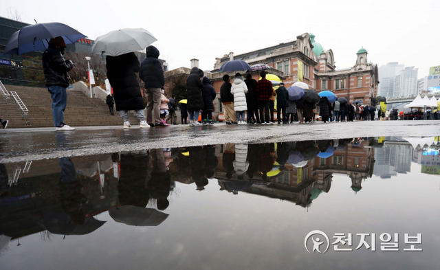 [천지일보=남승우 기자] 비가 내린 15일 오전 서울역 임시 선별검사소에서 시민들이 우산을 쓴 채 검사를 기다리고 있다. 이날 신종 코로나바이러스 감염증(코로나19) 신규 확진자는 7850명, 위중증 환자 수는 964명으로 집계되면서 역대 최다를 기록했다. ⓒ천지일보 2021.12.15