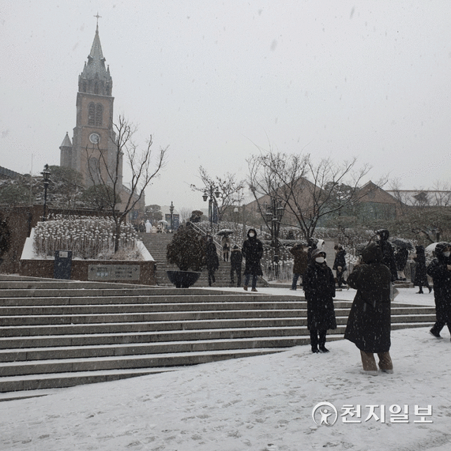 [천지일보=황해연 기자] 서울을 비롯한 수도권 서부에 18일 오후 올겨울 첫 대설주의보가 내려진 가운데 서울 중구 명동 성당 앞에서 시민들이 사진을 찍고 있다. ⓒ천지일보 2021.12.18