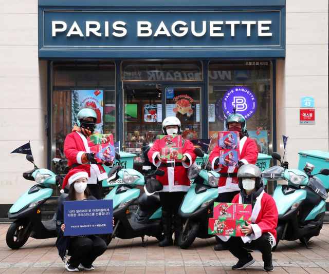 배민라이더들이 21일 파리바게뜨가 배달의민족과 협업해 어린이들에게 크리스마스 케이크를 선물하는 ‘산타 딜리버리’ 행사에서 출발하기 전에 파리바게뜨 명동본점에서 기념 촬영을 하고 있다. (제공: SPC그룹 파리바게뜨)
