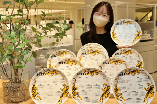 모델이 23일 서울시 송파구 잠실동에 위치한 롯데백화점 잠실점에서 ‘2022 범내려온다 달력접시’를 홍보하고 있다. (제공: 롯데쇼핑)