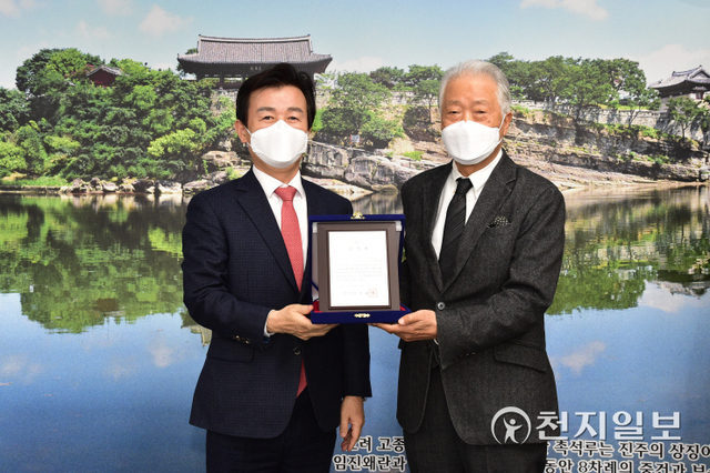 조규일 진주시장(왼쪽)이 23일 시청에서 조일상 예술감독에게 ‘2021 진주 전통공예 비엔날레’ 개최에 기여한 공로로 감사패를 수여하고 있다. (제공: 진주시) ⓒ천지일보 2021.12.23