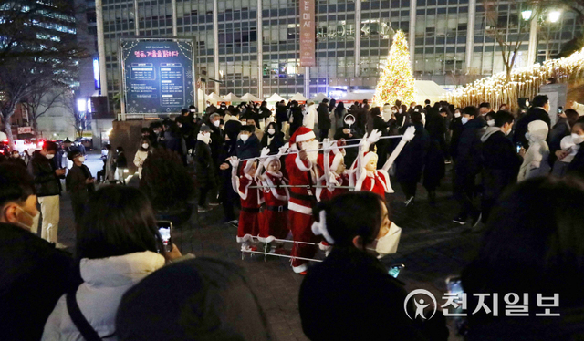 [천지일보=남승우 기자] 크리스마스 이브인 24일 저녁 서울 중구 명동성당 앞에서 시민들이 산타 공연을 즐기고 있다. ⓒ천지일보 2021.12.25