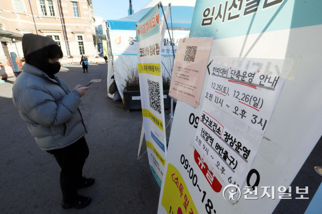 [천지일보=남승우 기자] 서울의 아침 기온이 영하 16도로 떨어지며 한파 경보가 내려진 가운데 26일 서울역광장 임시 선별검사소 입구에 한파 대비 단축운영 안내문이 붙어 있다. ⓒ천지일보 2021.12.26
